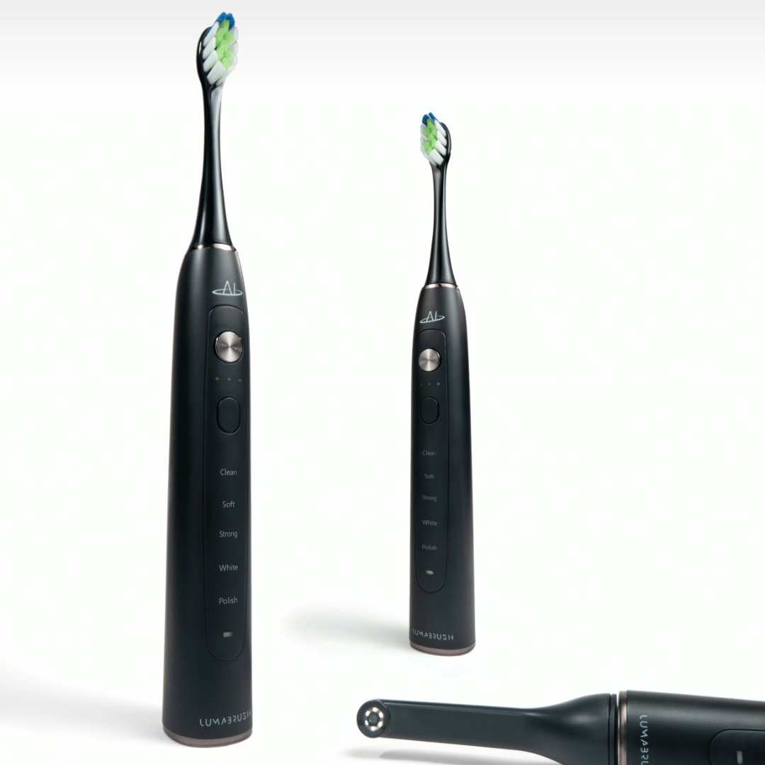 Two black LumaBrush electric toothbrushes with replacement heads on white background